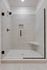 Luxurious walk-in shower featuring elegant tile work, built-in shelves, and a sleek glass door design.
