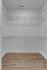 Spacious walk-in closet with chic wood flooring and ample shelving for organized storage.