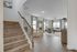 Inviting open-concept living area with elegant hardwood floors, cozy seating, and abundant natural light from large windows.