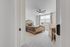 Inviting bedroom with elegant furnishings, plush carpet, and abundant natural light from a large window.