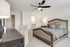 Chic bedroom with elegant wooden bed frame, plush pillows, and cozy lighting, offering a tranquil retreat.