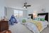 Bright and cheerful kids' bedroom with twin beds, a whimsical teepee, and playful animal-themed decor.
