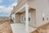 Inviting patio entrance to a modern apartment, featuring pristine siding and well-maintained surroundings under a clear blue sky.