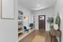 Modern entryway with stylish wooden flooring, built-in storage with wicker baskets, and elegant decor accents creating a welcoming atmosphere.