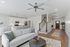 Modern open-concept living room with sleek kitchen, comfortable seating, and elegant staircase, perfect for contemporary living.