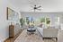 Bright and airy living room featuring modern furniture, stylish decor, and large windows revealing a beautiful outdoor view.