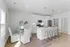 Elegant kitchen with white cabinets, stainless steel appliances, and a cozy breakfast bar in a bright, modern apartment.