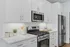 Modern kitchen with sleek stainless steel appliances, elegant white cabinetry, and polished countertops.