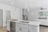 Modern open-concept kitchen and living area with sleek white cabinetry, stylish island, and elegant lighting in a bright, welcoming space.