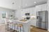 Modern kitchen with sleek white cabinetry, stainless steel appliances, and an inviting breakfast bar with stylish stools.