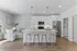 Bright, modern kitchen with sleek white cabinetry, stainless steel appliances, and a stylish island with pendant lighting and bar seating.