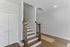 Elegant interior staircase with wooden railings and hardwood floors in a modern home setting.