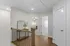 Elegant hallway with hardwood flooring and bright lighting, serving as a gateway to cozy bedrooms in a stylish apartment.