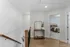 Elegant apartment hallway with wooden banister leading to a serene bedroom, showcasing stylish decor and a cozy atmosphere.