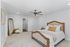 Elegant bedroom featuring a luxurious bed, stylish ceiling fan, and a classic mirrored corner adding charm and warmth.