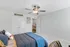Bright and airy bedroom featuring stylish twin doors, modern ceiling fan, and cozy bedding.
