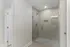 Elegant bathroom featuring a modern glass-enclosed shower with sleek tile design and built-in shelf.