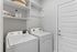 Modern laundry room equipped with sleek washer and dryer, ample shelving, and a stylish aesthetic for efficient home living.