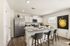 Contemporary kitchen with stainless steel appliances, chic bar seating, and large window letting in natural light.