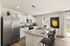 Modern kitchen with granite countertops, stainless steel appliances, and stylish island seating, bathed in natural light.