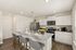 Modern kitchen with sleek white cabinets, granite countertops, a spacious island with seating, and state-of-the-art stainless steel appliances.