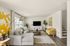 Bright and inviting living room with stylish contemporary decor, featuring a cozy gray sectional, vibrant yellow armchair, and modern art accents.