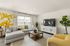 Modern living room with a stylish gray sectional sofa, vibrant yellow accents, and sleek entertainment area.