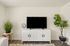 Modern living space with sleek white TV console, stylish decor, and lush green plants adding a fresh, vibrant touch.