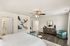Bright and spacious bedroom with stylish decor, featuring modern artwork, elegant furniture, and rich hardwood floors.