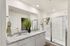 Modern bathroom with elegant double sink vanity and spacious glass shower, accented by sleek lighting and stylish decor.
