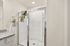 Modern bathroom with glass shower enclosure and elegant granite countertop, enhanced by fresh towels for a luxurious feel.