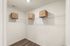 Spacious walk-in closet with modern shelving and stylish wicker storage baskets, perfect for organizing.