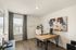 Bright and modern home office with sleek wooden desk, comfortable seating, and large window for natural light.