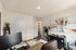 Bright home office with modern desk setup, large artwork featuring a baby, and sleek storage solutions.