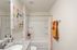 Bright and modern bathroom featuring a colorful abstract painting, stylish granite countertop, and vibrant polka dot shower curtain.