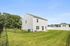 Modern two-story home with a spacious backyard, surrounded by lush greenery and a charming neighborhood setting.