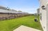 Spacious backyard with lush green lawn and modern fencing, perfect for outdoor activities and relaxation in a serene neighborhood.