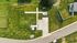 Breathtaking aerial view of a beautifully landscaped residential property featuring lush green lawns, a modern driveway, and a charming home situated in a peaceful neighborhood.