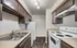 Modern kitchen with sleek brown cabinetry, stainless steel sink, and elegant lighting, perfect for culinary enthusiasts.