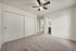 Bedroom with carpet flooring, ceiling fan, sliding closet doors, and nearby bathroom in affordable Bakersfield apartment
