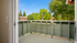 Bright and inviting balcony with green railings and lush tree views, creating a serene outdoor space.