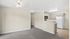 Bright open-concept apartment featuring a cozy living area, modern kitchen with appliances, and elegant neutral finishes.