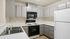 Modern kitchen with sleek gray cabinetry, stainless steel sink, and efficient appliances, perfect for culinary enthusiasts.
