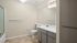 Elegant bathroom with modern fixtures, large mirror, and neutral tones creating a serene atmosphere.
