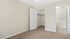 Inviting bedroom with plush carpet, open closet, and direct access to a modern tiled bathroom.