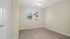 Bright, cozy room with soft carpet flooring and a window offering a pleasant view.