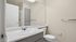 Modern bathroom with sleek fixtures, large mirror, and bright lighting. Perfect blend of style and functionality.
