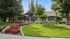 Charming residential building with lush landscaping, vibrant flowers, and a welcoming front entrance.