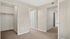 Spacious bedroom with plush carpet, ample closet space, and modern neutral walls in a stylish apartment.