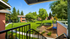 Charming outdoor view from a balcony overlooking lush green lawns, mature trees, and a colorful playground within a serene apartment complex.
